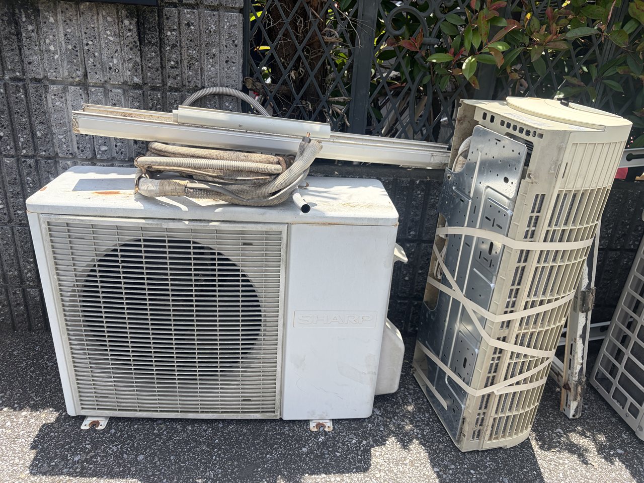 取り外して家の前に搬出された古いエアコンの室内機と室外機 / The old indoor and outdoor units removed and carried out to the front of the house